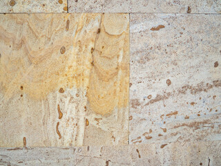 Yellow-brown material. Church cladding. Background from stone tiles. Interesting texture.