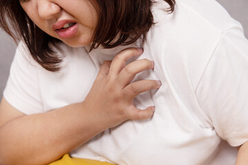 Fototapeta na wymiar Fat Asian Woman Grab Her Chest with Pain From Heart Attack