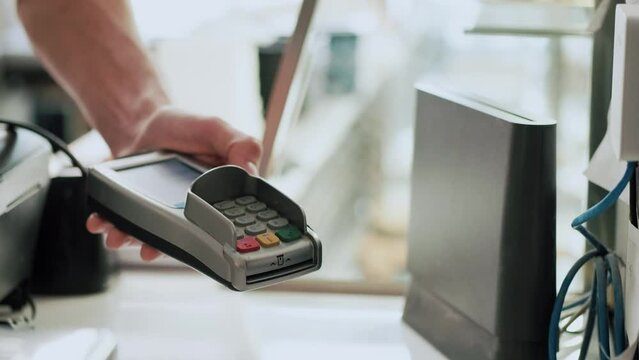 Video of customer using her credit card to make payment with electronic reader in the restaurant.