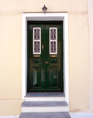 Fototapeta na wymiar An elegant classic house entrance with green painted door, Chora town, Andros island, Greece.
