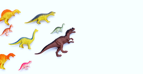 Fototapeta premium Plastic dinosaur toys on white background. Top view