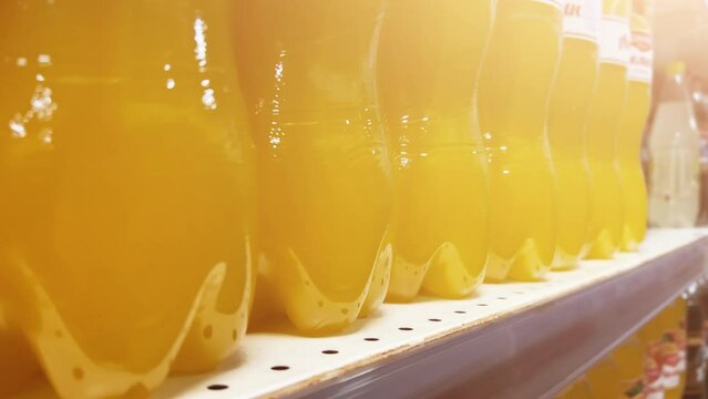 Citrus lemonade in plastic bottles is on the shelves of grocery store. Closeup