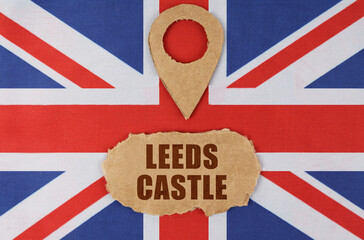 On the flag of Great Britain lies a symbol of geolocation and cardboard with the inscription -...
