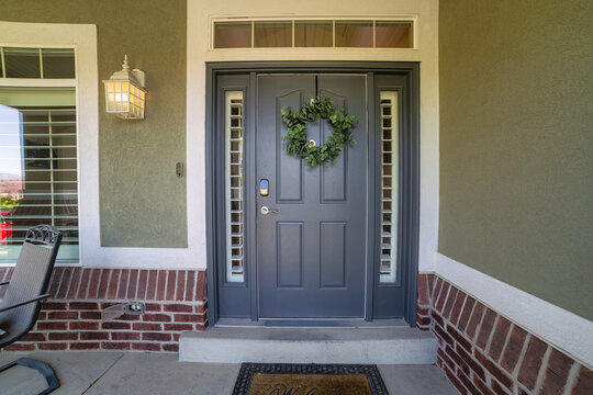 Closeup shot of a blue front door decorated with a holiday wreath