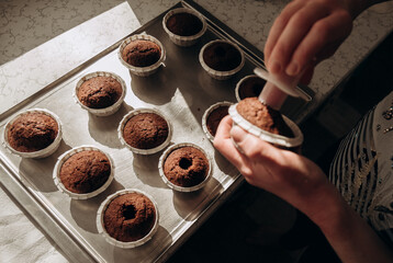 Chocolate muffins. Homemade chocolate muffins. The process of making homemade chocolate cupcakes with whipped cream.