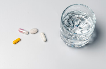 Tablets with a glass of water.