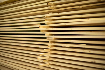 Lot of boards in carpentry workshop. Boards are stacked.