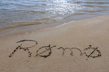 Fototapeta premium Rømø written in the sand at the beach.
