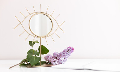 Flatlay composition with blank paper notepad, lilac flower, mirror on white wooden background. Flat lay, top view still life concept.