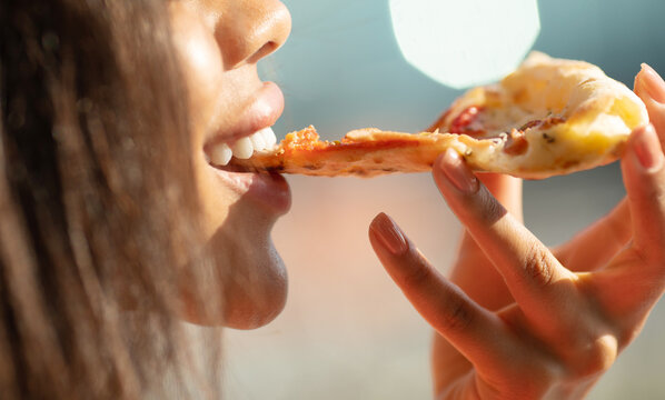 Black Woman Hand Takes A Slice Of Meat Pizza. Young Woman Eating Pizza Outdoor In Street.