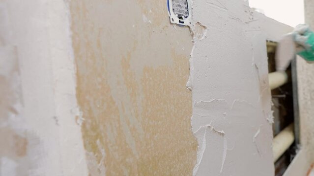 a woman puts plaster on drywall walls, self-repair of the interior