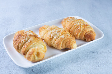 Gourmet cheese and sesame croissant, displayed on gray background
