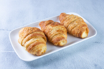 Gourmet cheese and sesame croissant, displayed on gray background