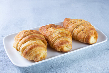 Gourmet cheese and sesame croissant, displayed on gray background
