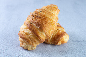 Gourmet cheese and sesame croissant, displayed on gray background
