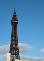 The historic 19th century blackpool tower against a sunlit blue cloudy sky