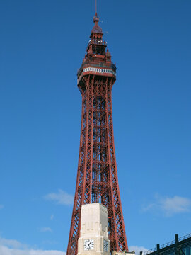 The historic 19th century blackpool tower against a sunlit blue cloudy sky
