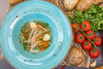 Chicken broth with homemade pasta, carrots, fillets and quail eggs