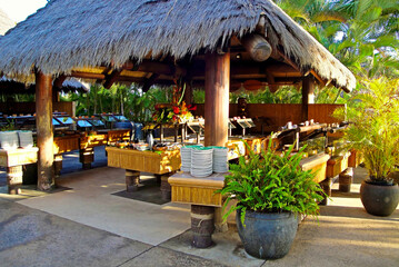 Alcove with a thatch roof with dining preparations for a luau on Maui, Hawaii