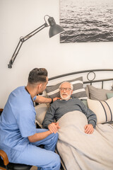 Male physician visiting an ill aged man
