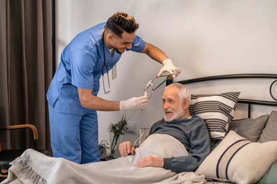 Healthcare professional preparing an aged patient for a medical procedure