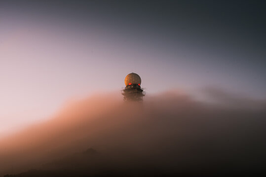 Low angle shot of a radar tower with dense clouds - Powered by Adobe