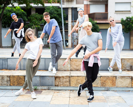 Group of dancing teenagers posing at city street. Hip hop dancers