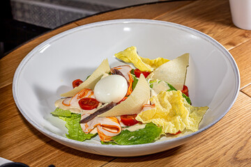 Cobb salad with blue cheese sauce. Traditional american dish made of salad leaves, avocado, cherry tomatoes, fried chicken and bacon slices, celery, cheese and boiled egg.