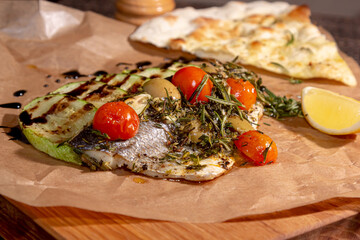 Grilled Dorado fish with arugula salad and tomatoes. Black background. top view