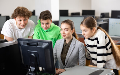 Fototapeta premium Teacher helping young student in computer class in university