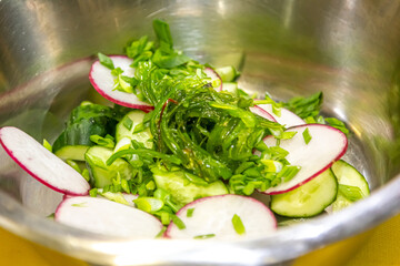 Kale, avocado, radish, cucumbers, olive oil salad and soft boiled egg - delicious healthy breakfast, snack on a light background