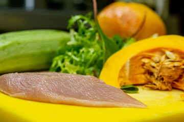 Raw chicken breast fillets and vegetable on wooden background