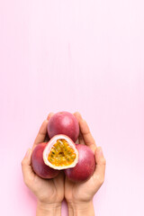 Passion fruit with hand on pink, Tropical fruit in summer season