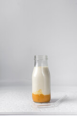 Mango milk in a classic milk bottle, mango puree and whole milk in a transparent bottle, mango milkshake