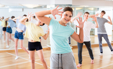 Fototapeta na wymiar Positive teenagers are dancing hip hop in dance studio