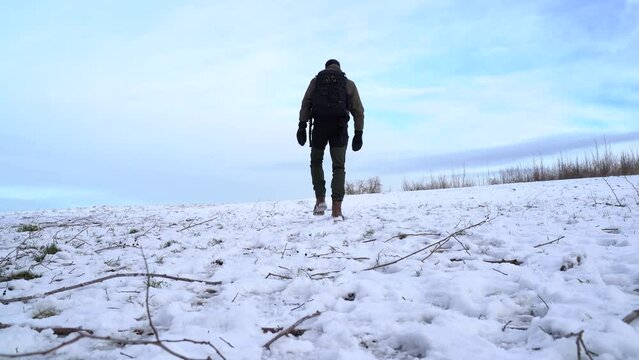 a man walks across a field with a lot of snow
