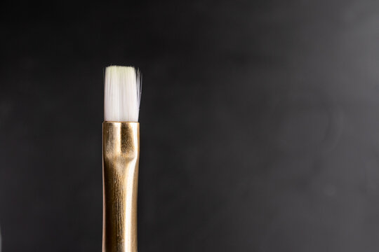 detalle de cabeza de pincel de punta plana usado con fondo de madera negra con textura