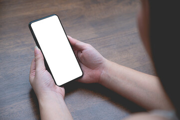 Close up women using a smartphone with an empty white screen at the wooden interior cafe.