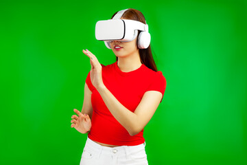Asian woman in vr glasses, playing video games with virtual reality headset and trying to touch something with hands, isolated green background, Metaverse Concepts