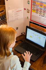 Overview of little girl using computer for school work