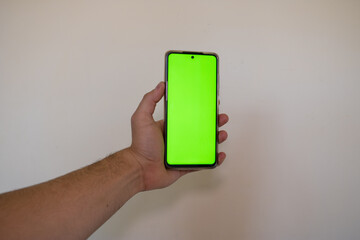 Celular sostenido con pantalla verde ideal para edición 