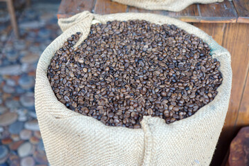 Roasted coffee bean in a brown sack.                      