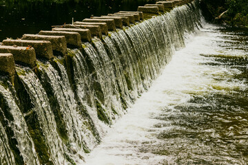 Caída de agua en cascadas y detalle de pasos peatonales sobre arroyo serrano