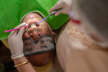 Patient in a dental clinic in a stretcher while the dentist examines him