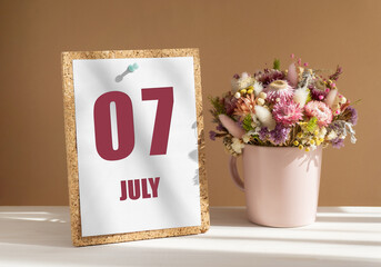 july 7. 7th day of month, calendar date.Bouquet of dead wood in pink mug on desktop.Cork board with calendar sheet on white-beige background. Concept of day of year, time planner, summer month