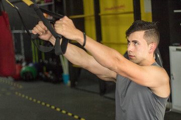 Hispanic sporty man doing total resistance exercises