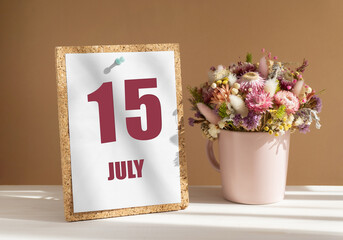 july 15. 15th day of month, calendar date.Bouquet of dead wood in pink mug on desktop.Cork board with calendar sheet on white-beige background. Concept of day of year, time planner, summer month