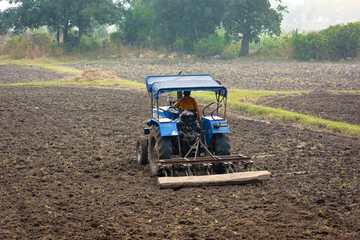 Indian farmer working with tractor in agriculture field © Sahil Ghosh