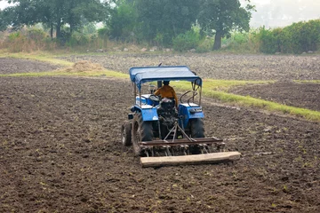 Poster Indian farmer working with tractor in agriculture field © Sahil Ghosh