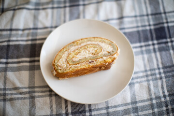 Delicious Cake Roll with Vanilla Cream on a plaid tablecloth